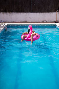 Man relaxing in inflatable ring on swimming pool