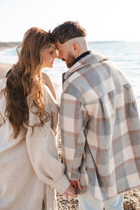 Side view of young woman looking away at beach