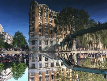 Reflection of people by building in canal