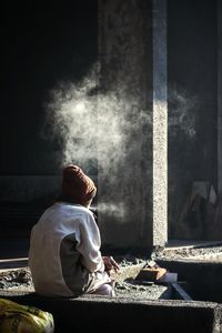 Rear view of woman sitting on table