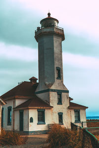 Lighthouse by sea against sky