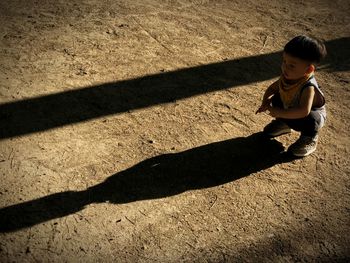 High angle view of girl on shadow on sunny day
