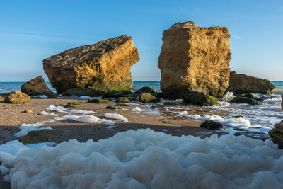 Rocks on beach against sky