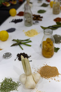 Spices and herbs finely chopped with lemons, onions and other vegetables on the white table.