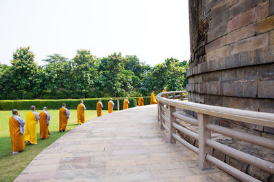 Group of unidentified buddhist monk rounding near dhamek stupa in sarnath near varanasi city, india