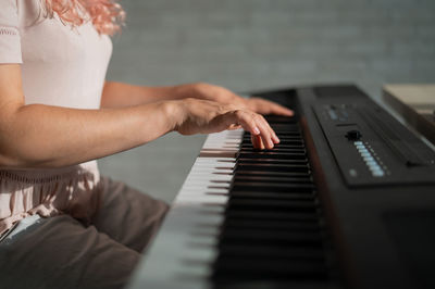 Midsection of woman playing piano