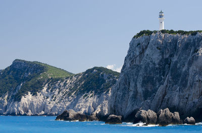 Rock formations by sea against clear sky