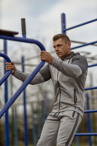 Side view of man standing in cage