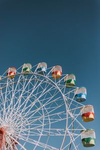 Low angle view of ferris wheel against blue sky