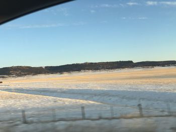 Scenic view of land against clear sky during winter