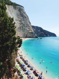 High angle view of people enjoying at beach against clear sky