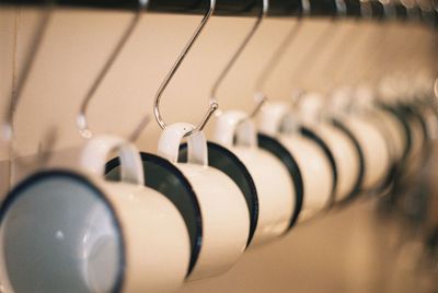 Close-up of cups hanging on metallic hook