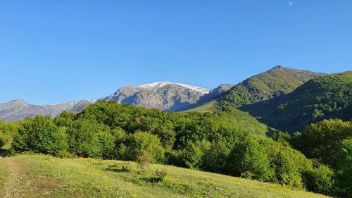 Scenic view of mountains against clear blue sky