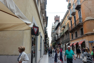 People walking on street in city against clear sky