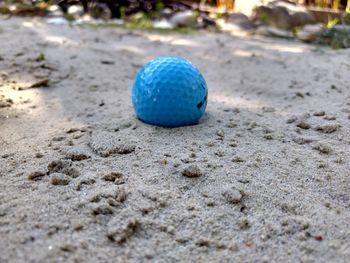 Close-up of blue ball on sand