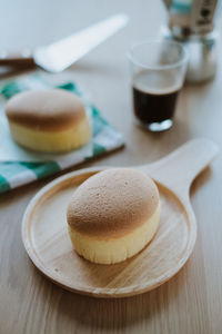 Wooden desk with japanese cheesecake and cup of coffee in morning, close up.