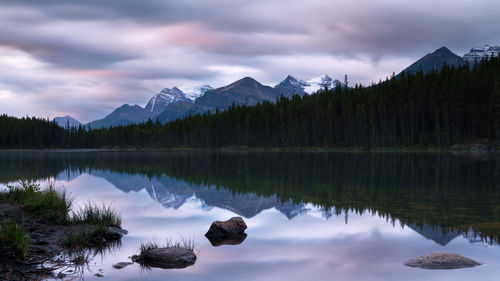 Scenic view of lake by mountains against sky