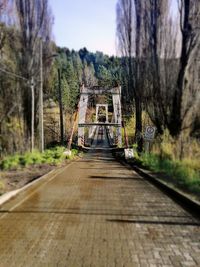 Footbridge amidst trees against sky