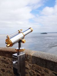 Metallic structure on beach against sky