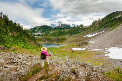 Rear view of woman on mountain against sky