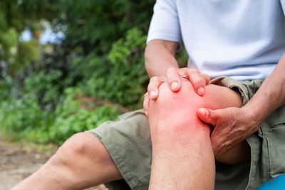 Midsection of man sitting on hand