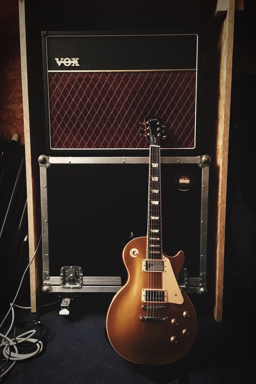 CLOSE-UP OF GUITAR IN BLACK BACKGROUND