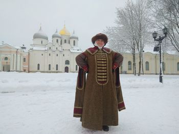 Portrait of young man standing on snow covered temple