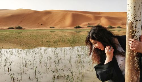 Side view of young woman standing on landscape