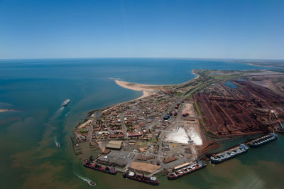 High angle view of cityscape by sea against clear sky