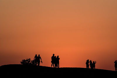 Silhouette people  against sky during sunset