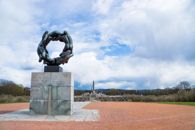 Low angle view of sculpture at gustav vigeland sculpture park against cloudy sky