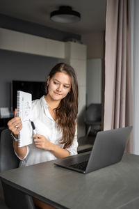 Young woman using laptop at home