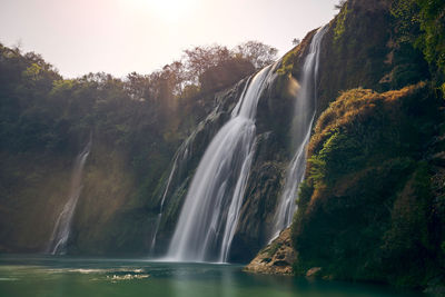 Scenic view of waterfall against sky