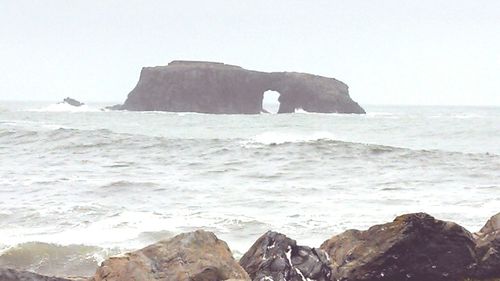 Scenic view of cliff by sea against sky