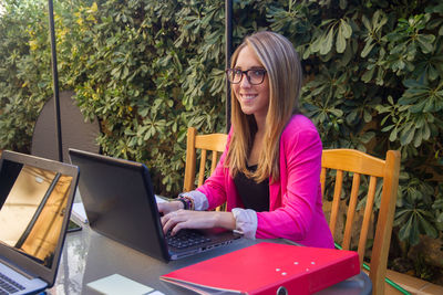 Portrait of woman using laptop at cafe