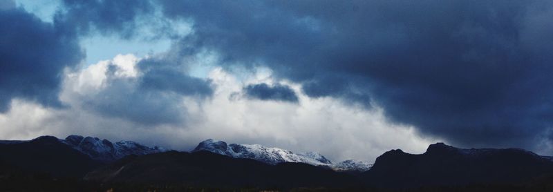 Low angle view of snowcapped mountains against sky