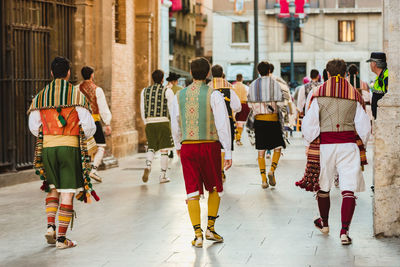 Rear view of people walking on street