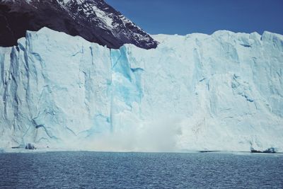 Scenic view of sea against snowcapped mountain