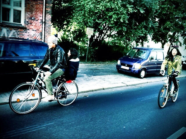 bicycle, transportation, mode of transport, land vehicle, riding, street, parked, stationary, parking, car, on the move, road, men, cycling, motorcycle, travel, building exterior, tree