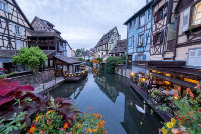 Canal amidst buildings against sky