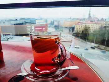 Close-up of tea on table in city against sky