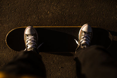 Teen looking down at feet on skateboard