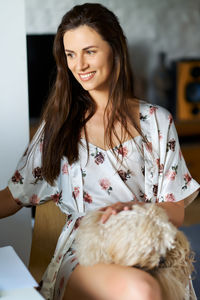 Portrait of young woman sitting at home