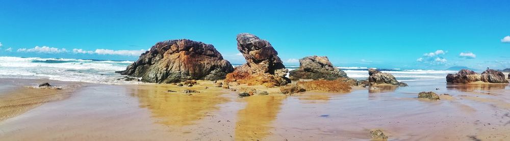 Panoramic view of beach against clear blue sky