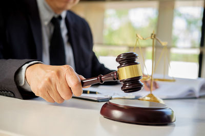 Midsection of judge sitting at desk in courtroom