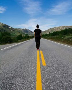 Rear view of man standing on road