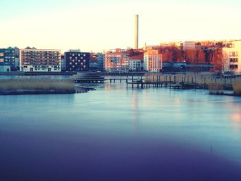 River by buildings against sky in city