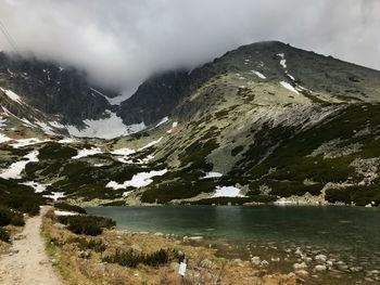 Scenic view of lake by mountains against sky