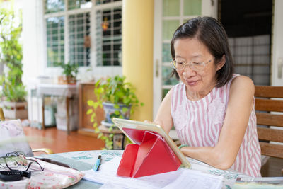 Senior asian woman using digital tablet to work from home