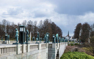 Sculptures in vigeland park against cloudy sky